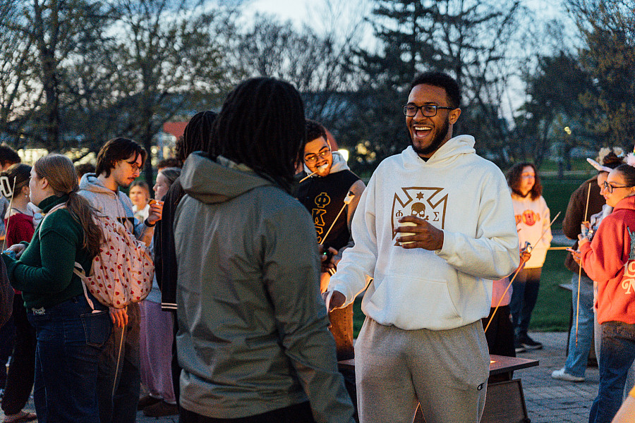 Greek Week Opening Ceremony students at campfire