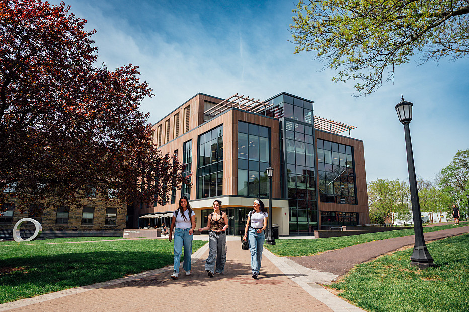 IDC in background with 3 students walking